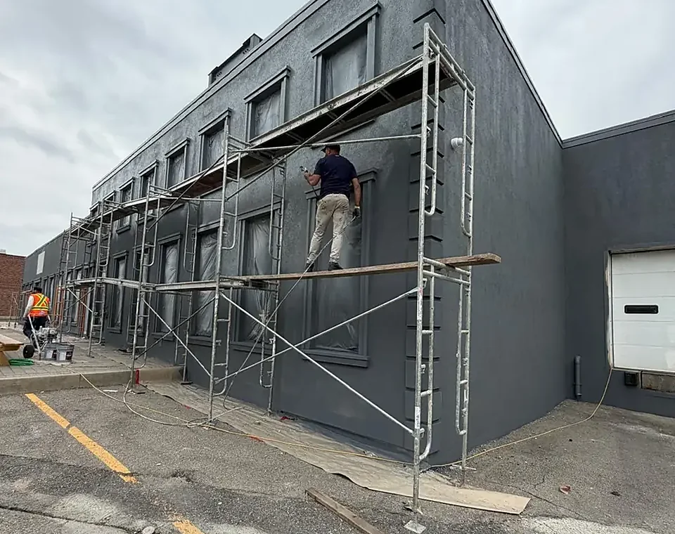 A FAIME crew on scaffolding refinishing the exterior of an occupied commercial building in Vaughan