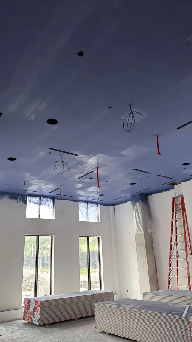 High open commercial ceiling sprayed in a deep navy finish in Scarborough