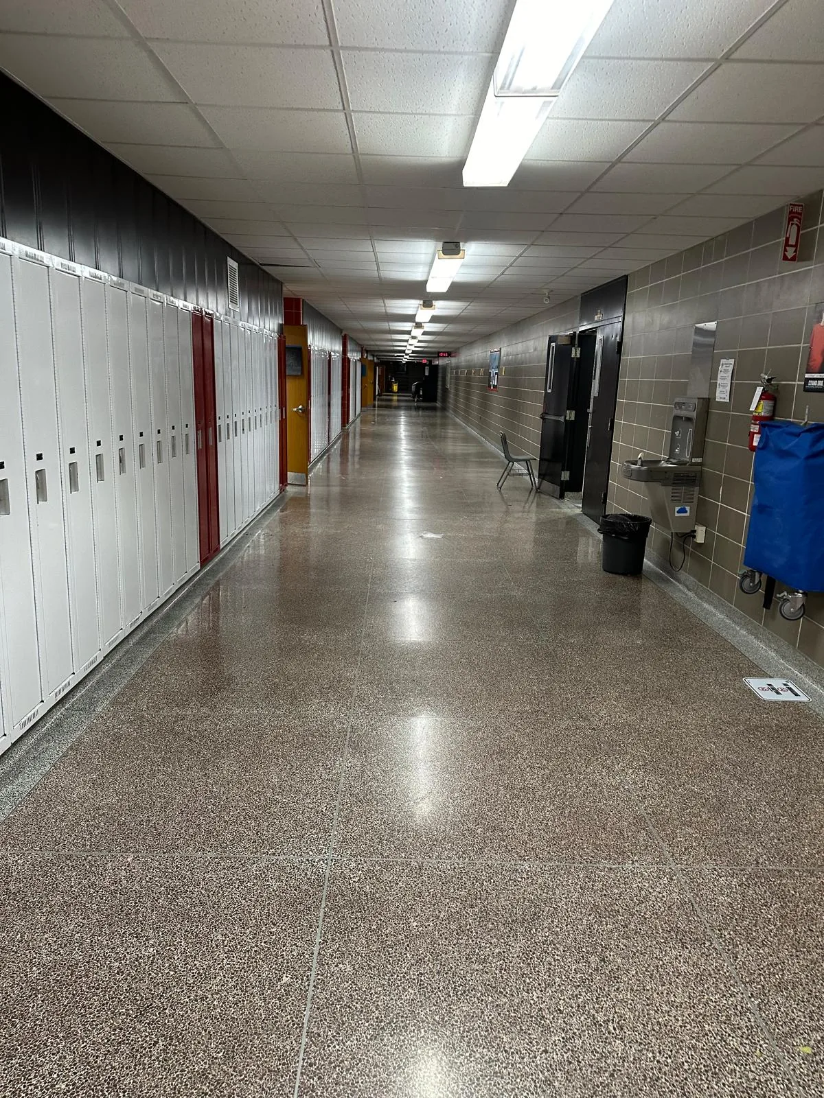 A long locker corridor with refinished doors and frames along one side
