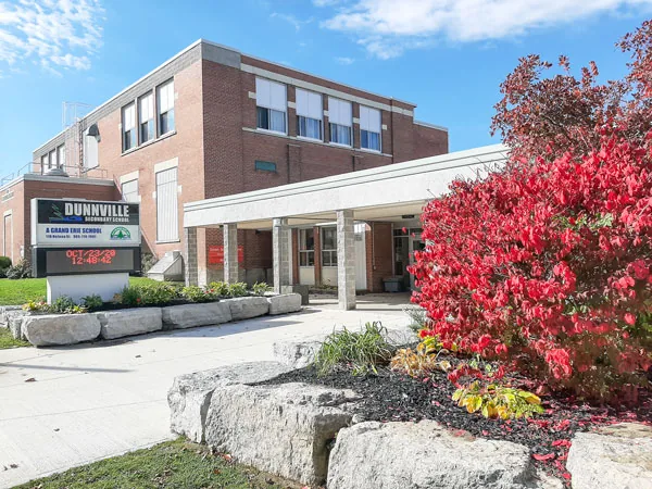The front entrance of Dunnville Secondary School with the school sign and landscaping