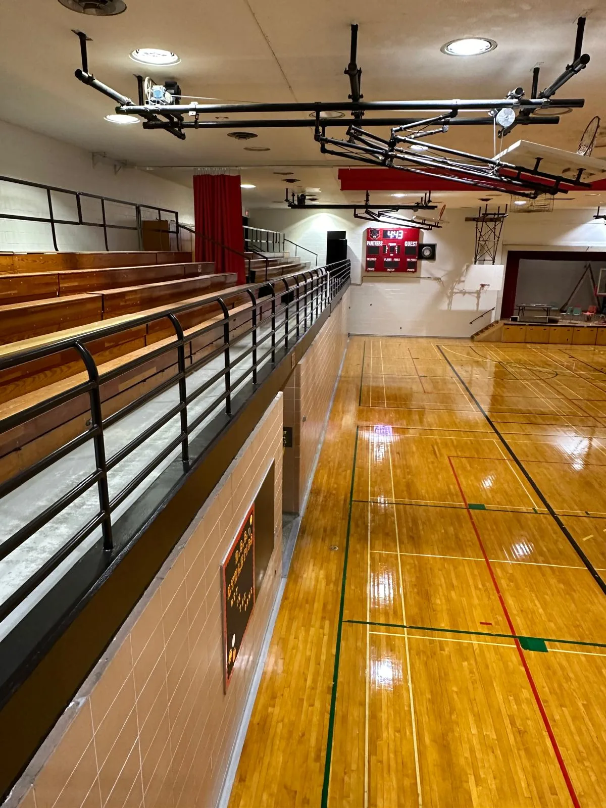 The gymnasium balcony and bleachers above the court, with repainted walls