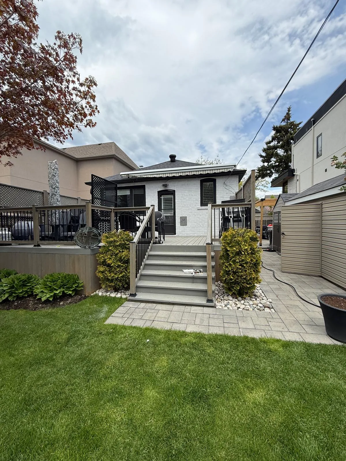 After: the rear of the house in white painted brick above the back deck and stairs