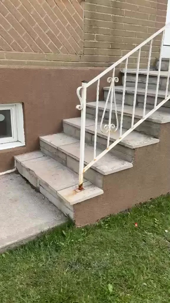 Finished front entrance with the white railing and steps, porch foundation in tinted stucco