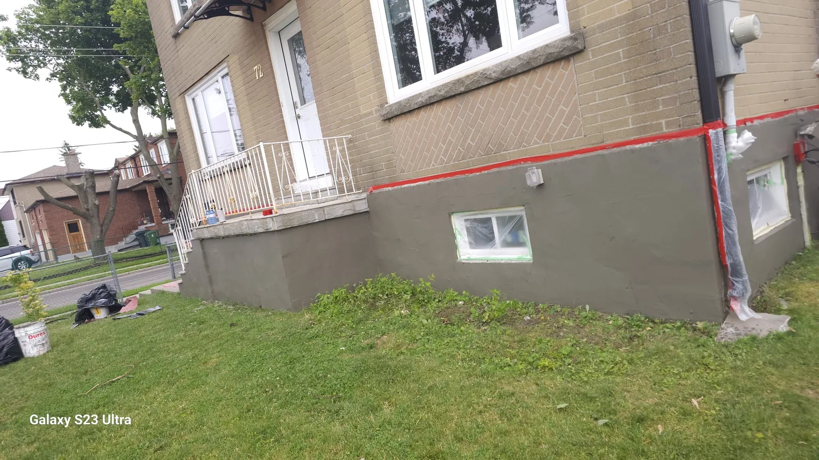 Front foundation in grey base coat with basement windows framed square