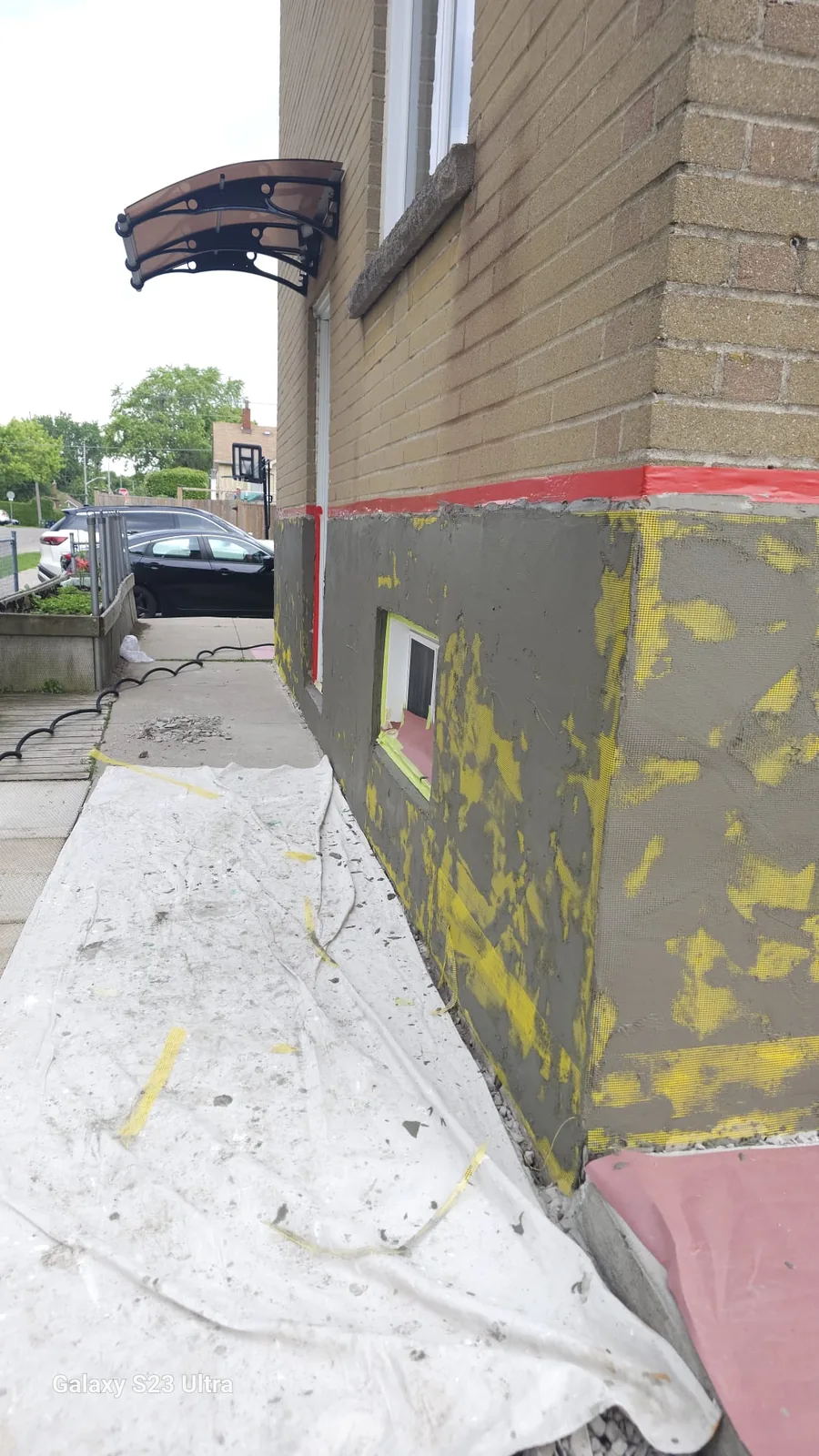 Fibreglass reinforcing mesh embedded in the cementitious base coat at the corner