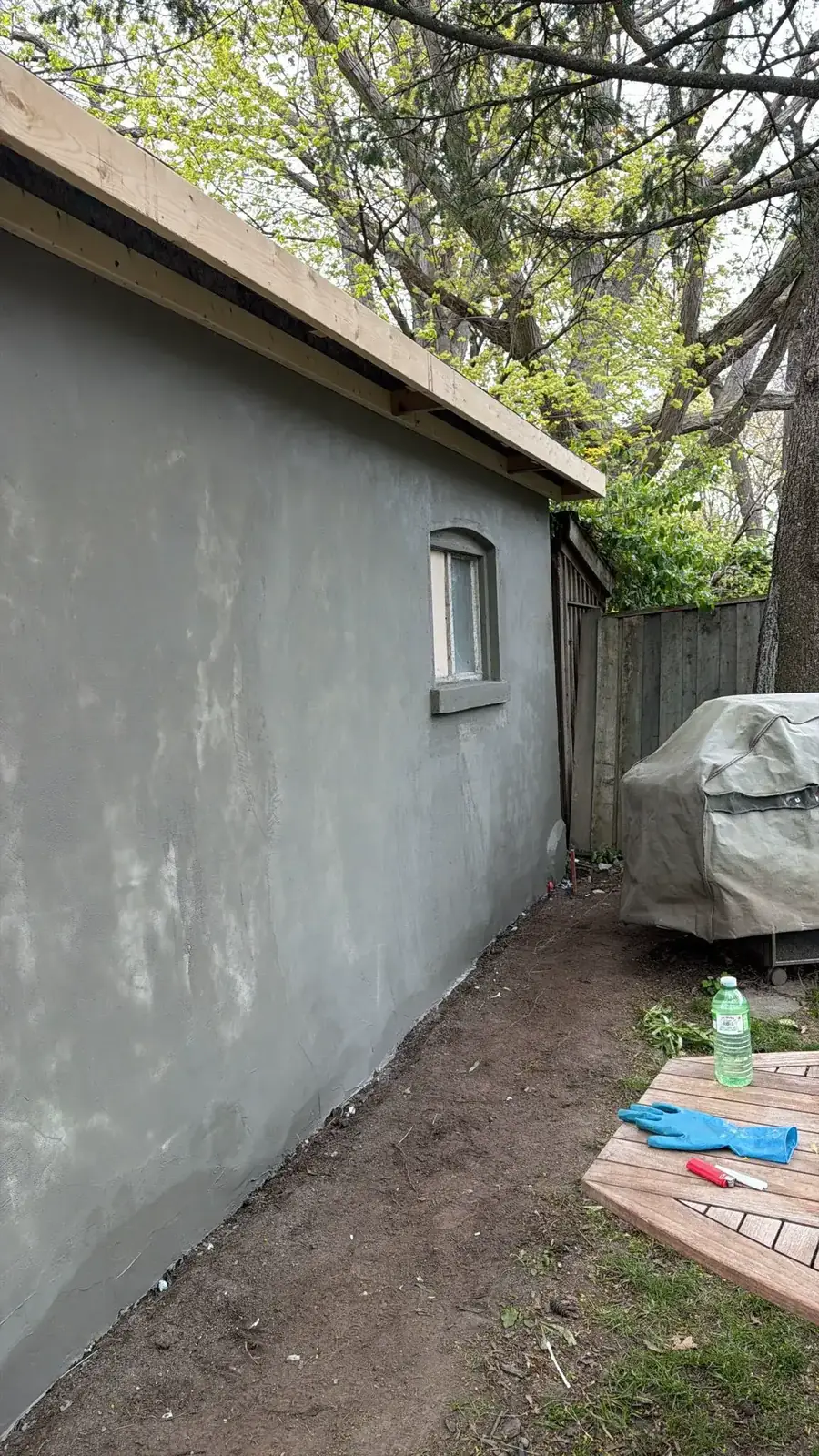 Fresh grey cementitious base coat on the garage side wall