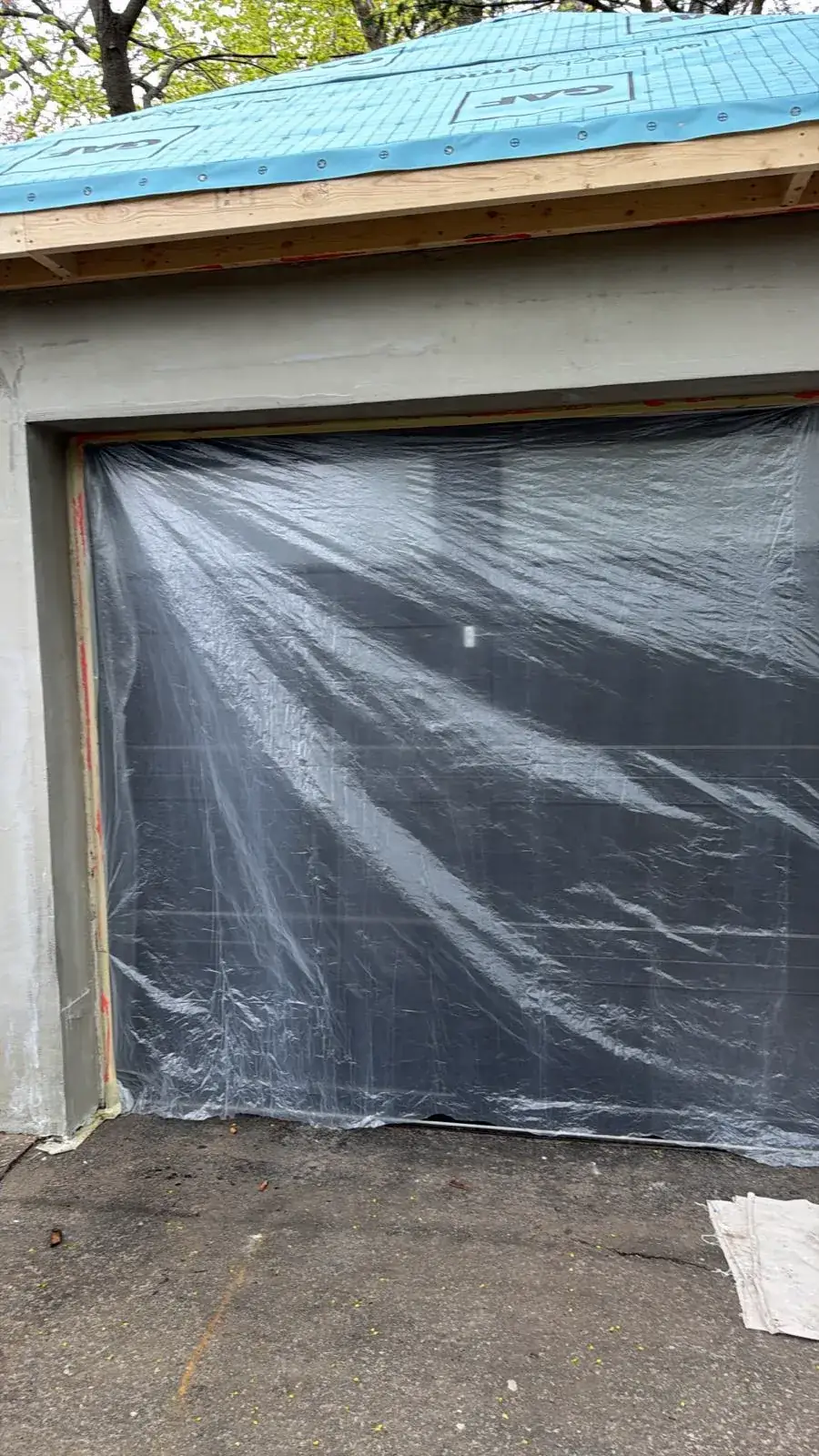 Garage door fully masked in poly sheeting before the finish coat