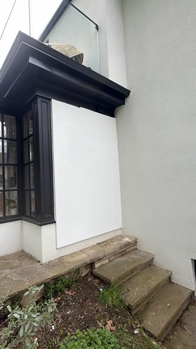 House wall infill finished in seamless white — part of the exterior stucco project