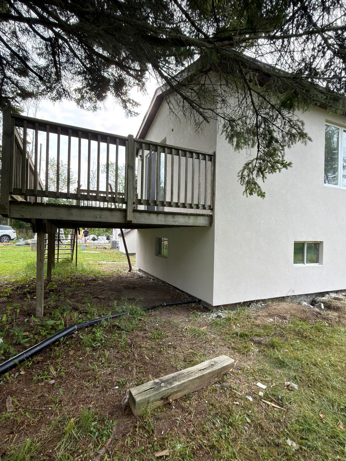 Finished wall carried underneath and around the raised rear deck of the bungalow