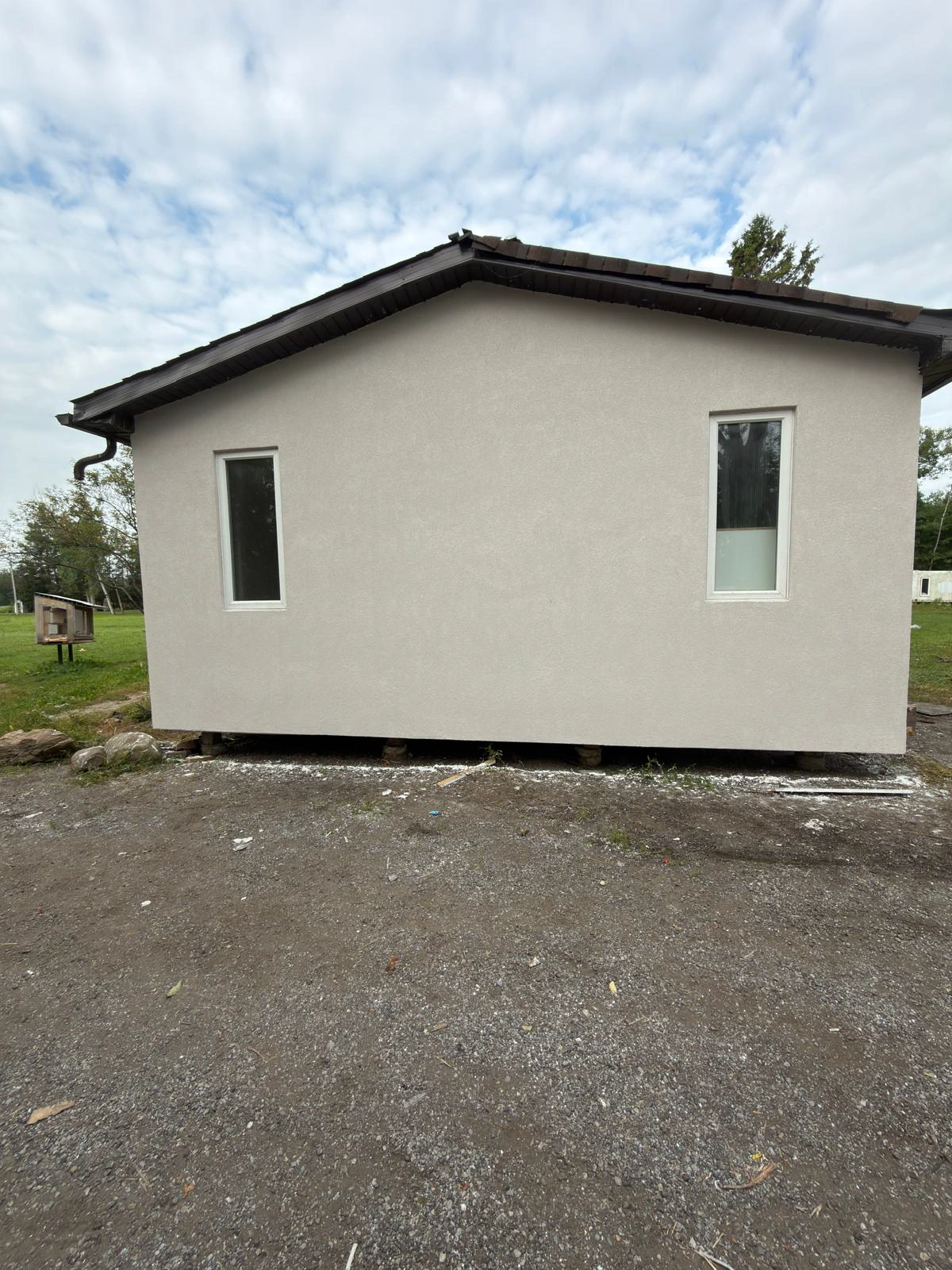 The driveway gable end finished in the final coat, squared and clean with the site cleared