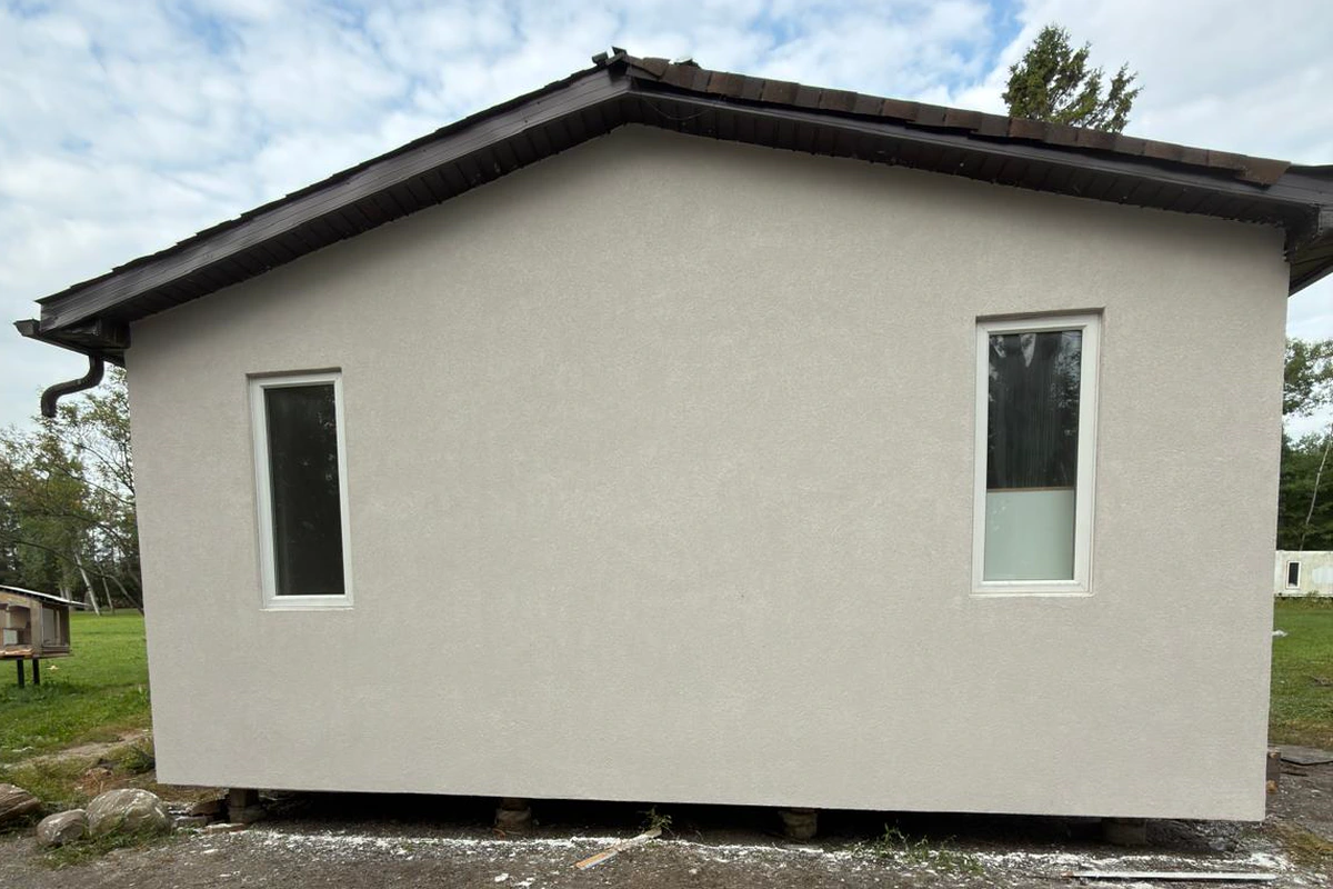 The finished driveway gable end of the bungalow with a flat textured finish and clean window surrounds