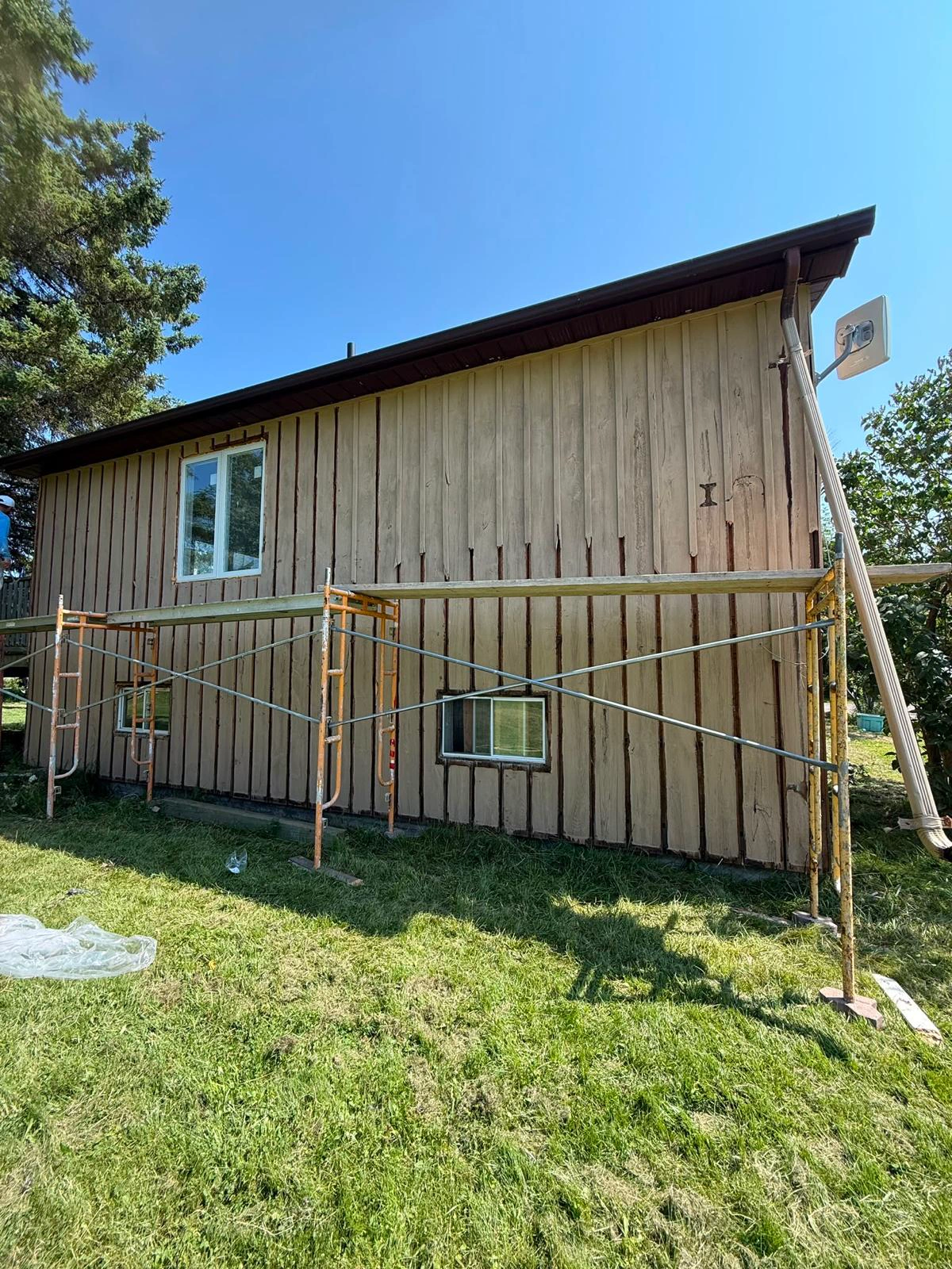The long side elevation of the bungalow on scaffold with the original vertical boards still in place