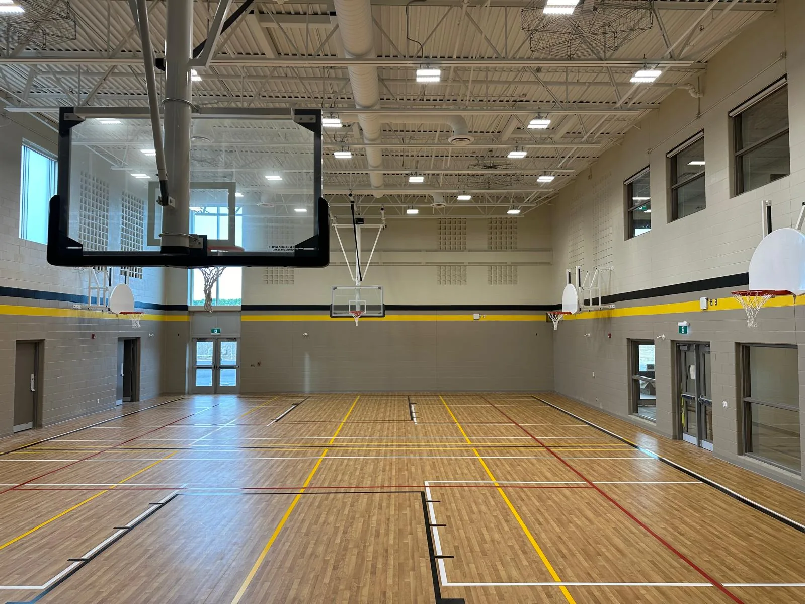 The new gymnasium with freshly painted walls and a dark accent band above the court