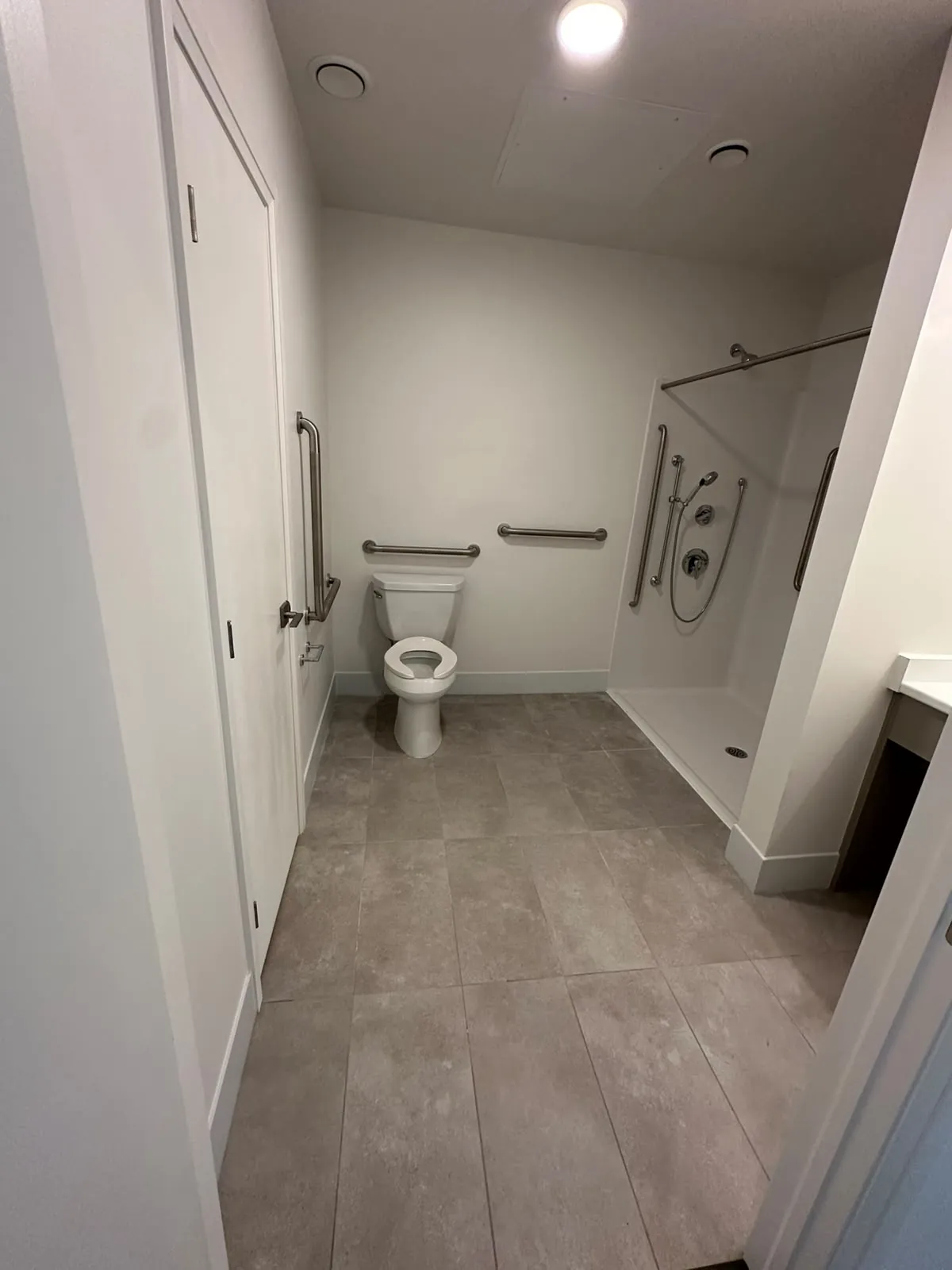 An accessible bathroom with grab bars, a barrier-free shower and painted walls and ceiling