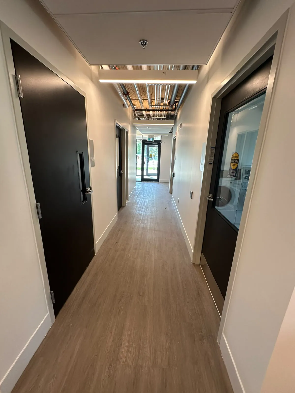 A residential corridor with painted walls and dark suite doors
