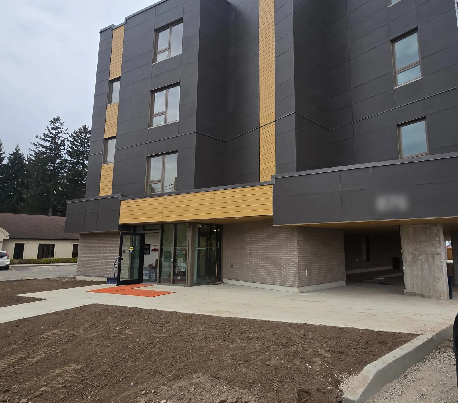 The completed four-storey KW Habilitation building with brick at the main level and dark fibre-cement siding above