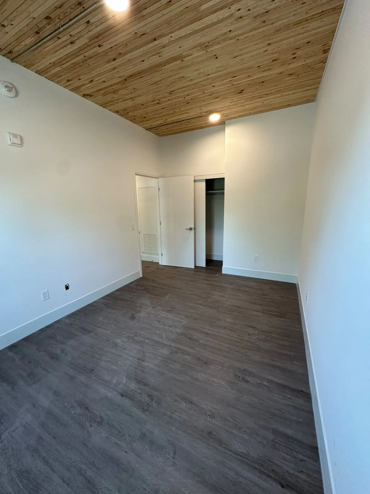 A suite living area with painted walls, door frames and a timber ceiling