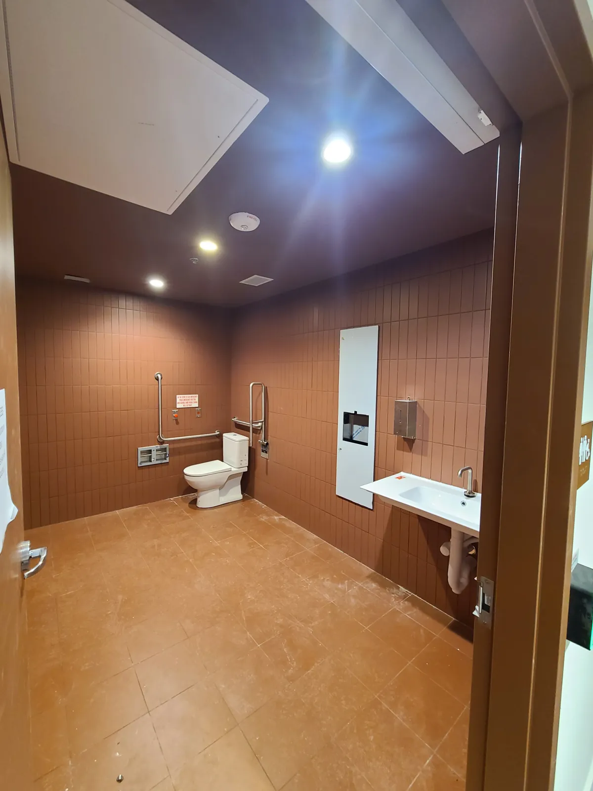 An accessible washroom with a painted ceiling and finished door frame