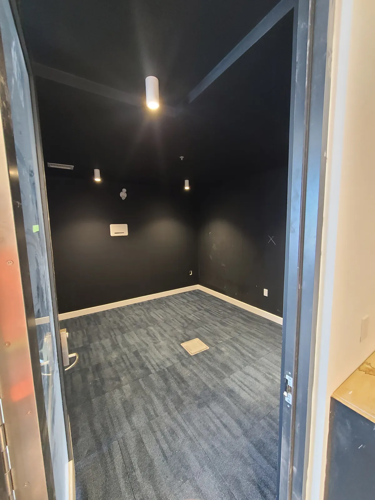 An amenity room with walls and ceiling finished in a dark colour