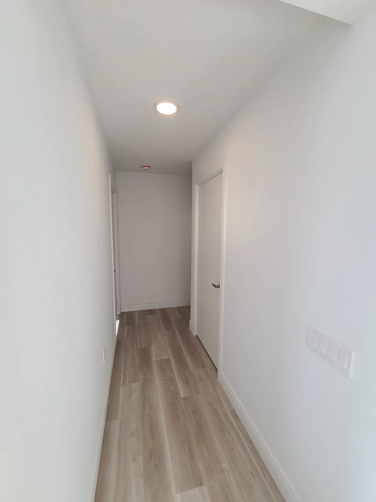 A suite hallway with painted walls, door and baseboards