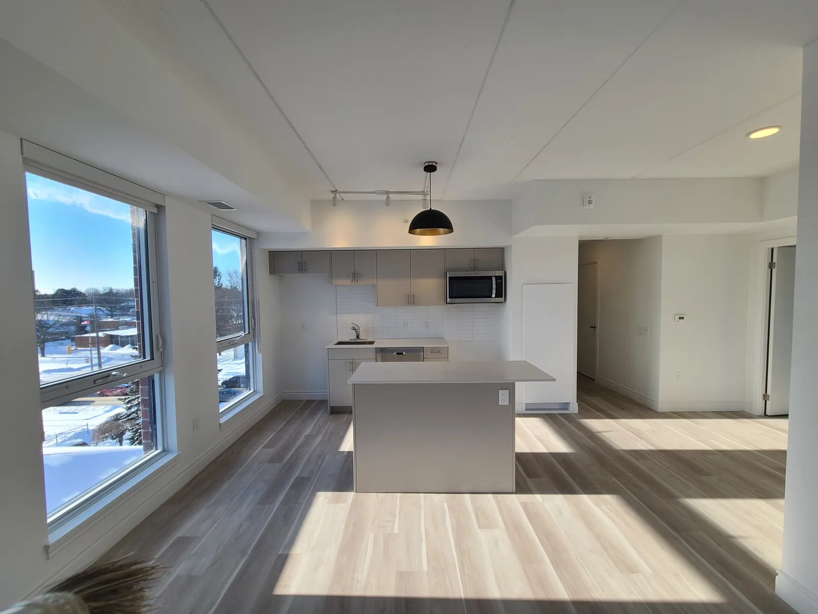 A finished suite at Oakley Ridge in Guelph, with freshly painted walls and ceiling, a kitchen island and large windows