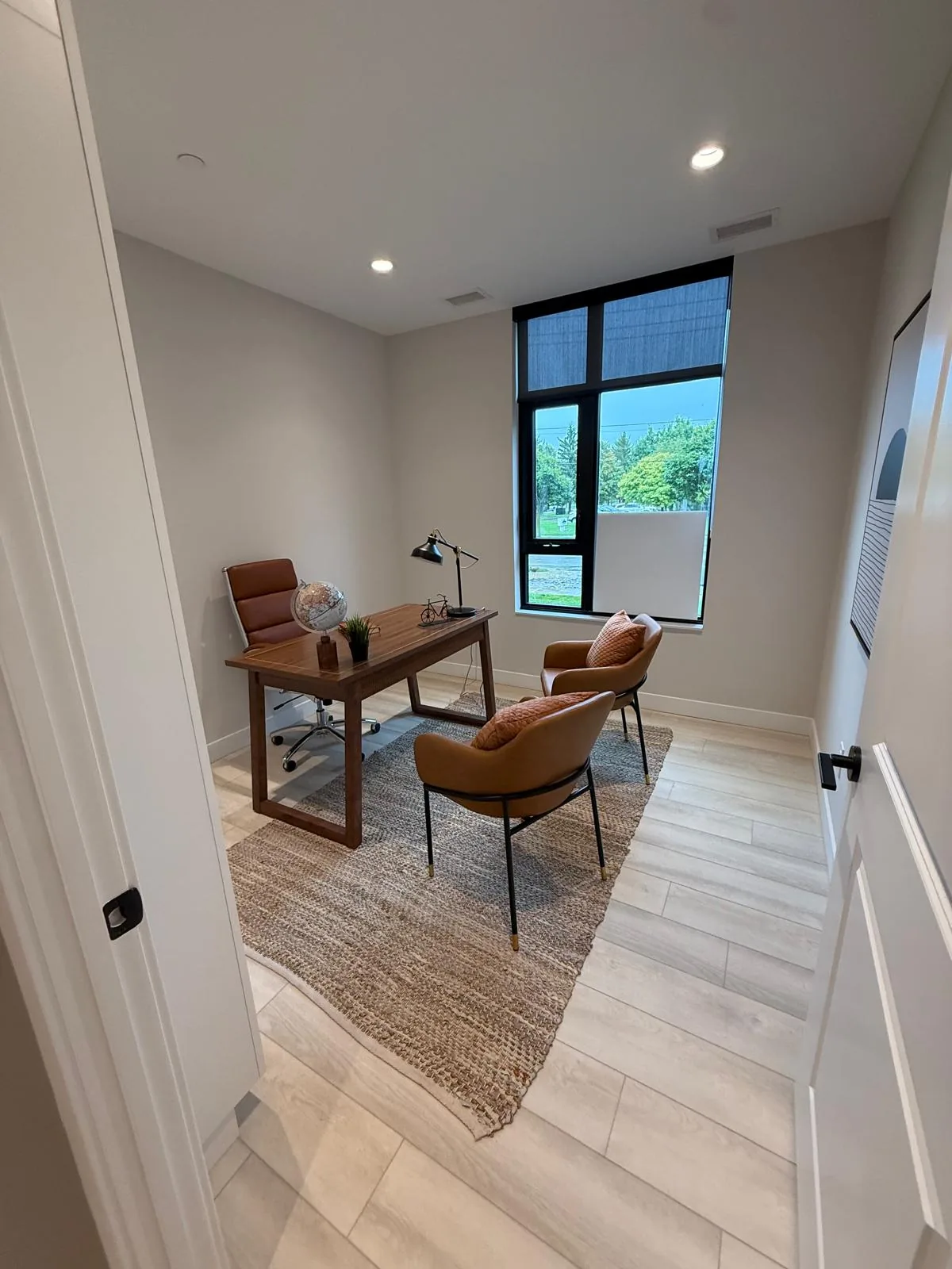 A suite den set up as a home office, with painted walls, trim and door