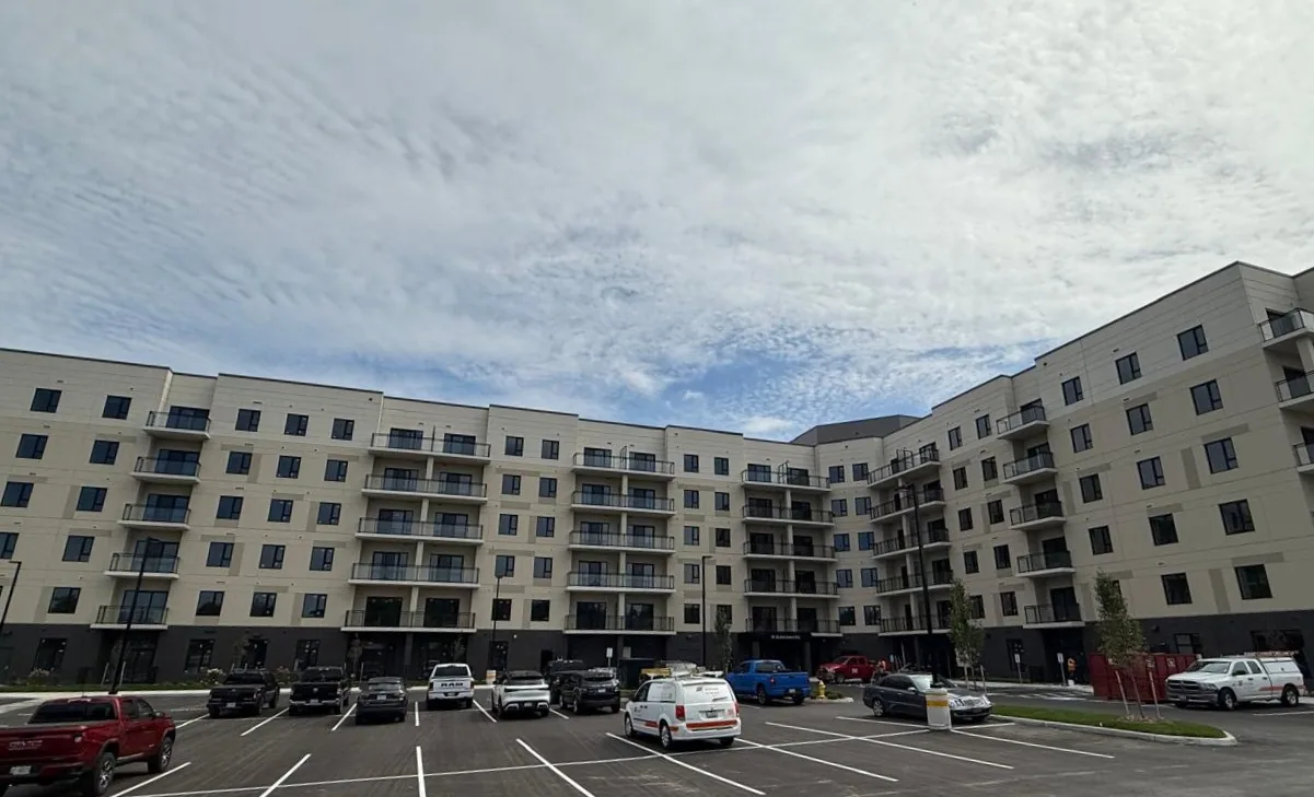 The Queensland Condos building seen from its parking area, with balconies on every floor