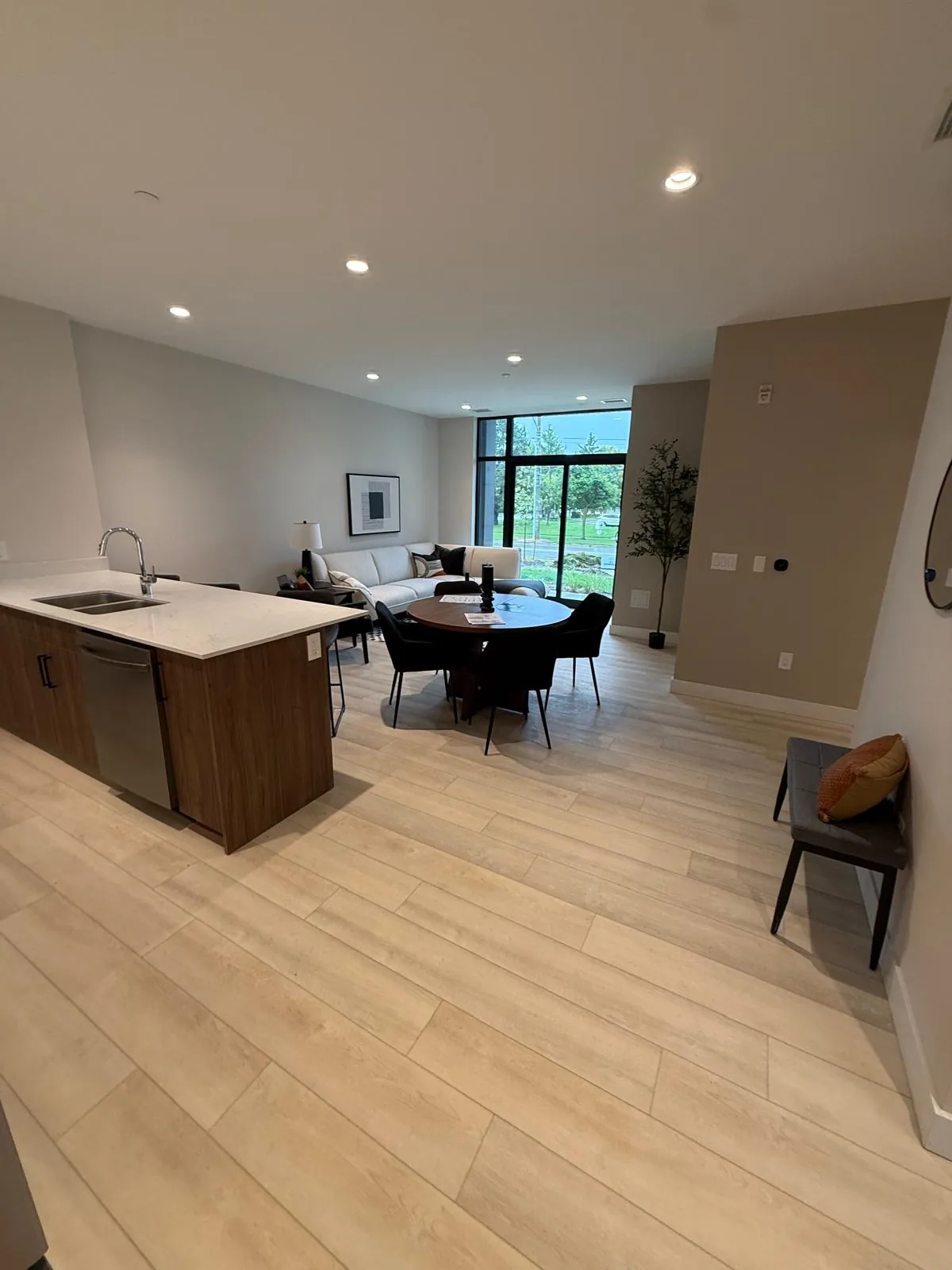 A suite kitchen and dining area with finished walls and ceiling, looking toward the balcony windows