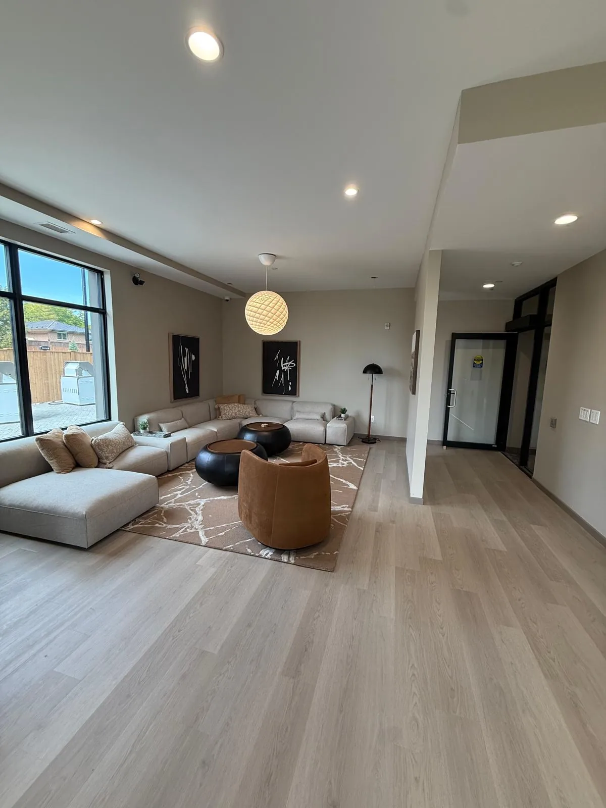 An open-plan suite living area with light walls, a flat white ceiling and a painted suite entrance door