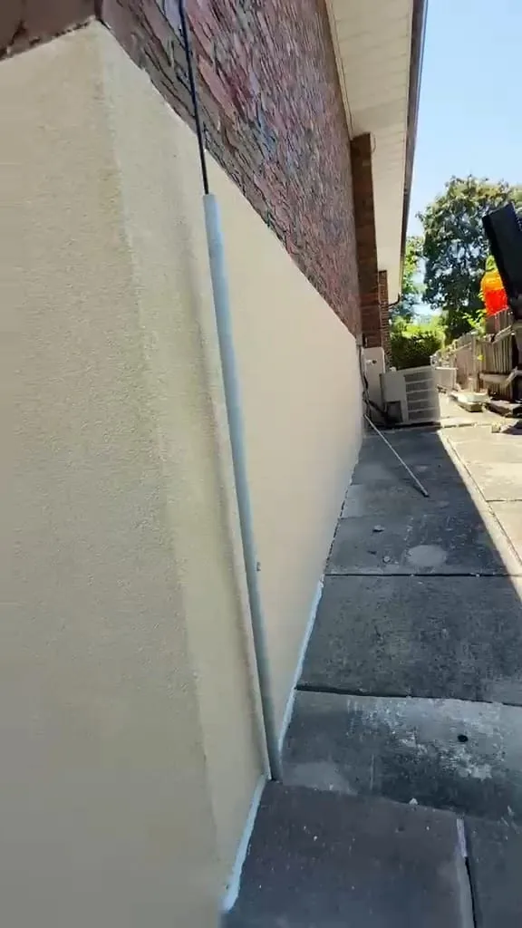 Finished garden corner with a bold clean caulk line along the bottom of the wall
