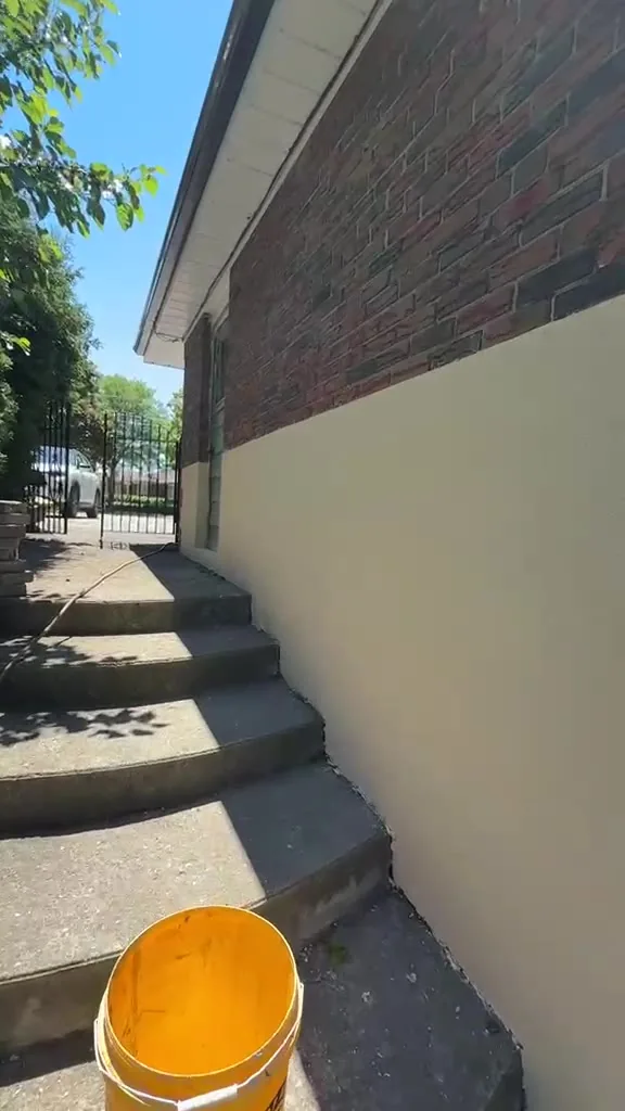 Finished stucco along the side steps with the top line straight against the brick