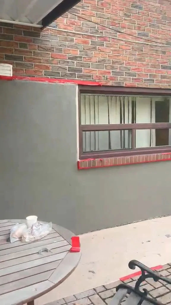 Patio window wall in grey base coat framed square around the window