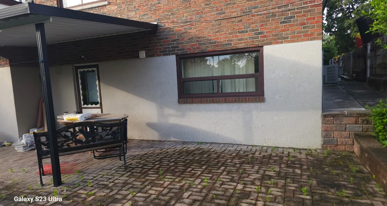 Patio wall of the Scarborough home with the old worn coating before stucco refinishing