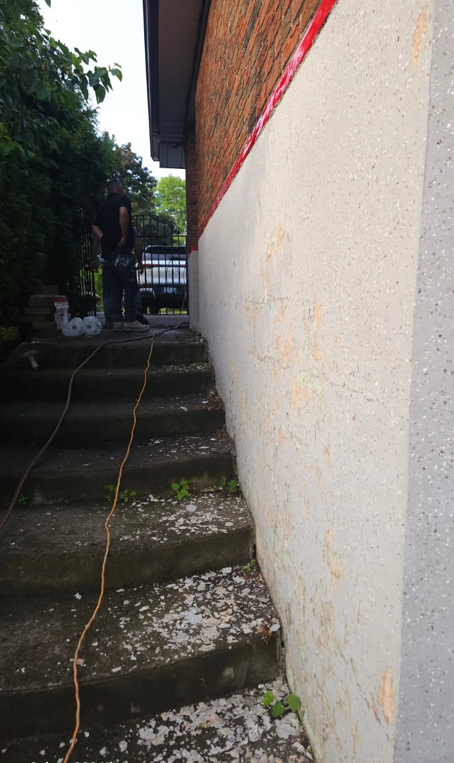 Wall along the side steps after grinding with loose coating stripped and debris on the steps