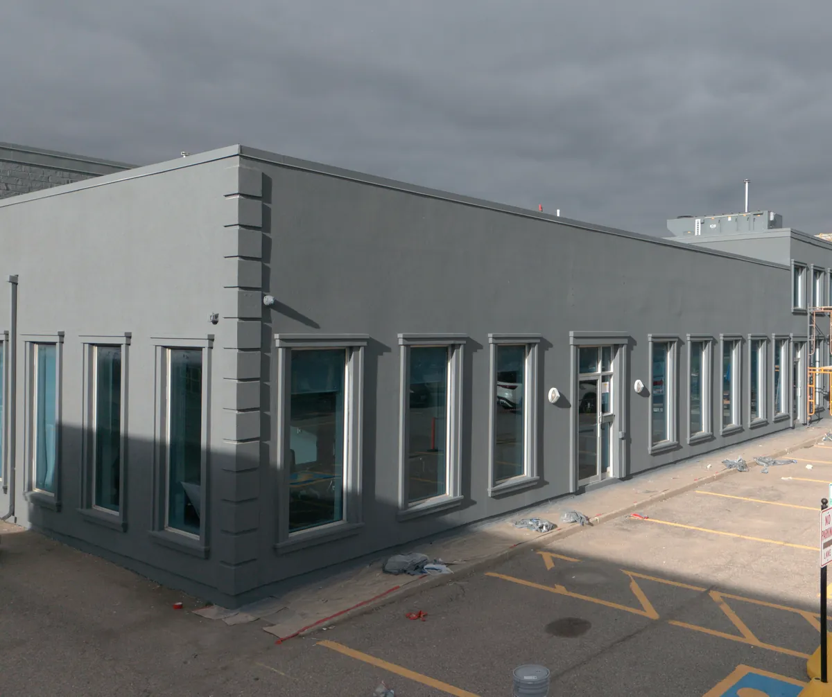 Drone view of the long elevation finished in dark grey with light trim around every window