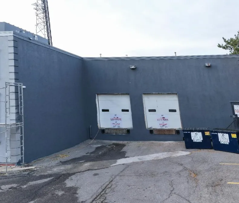The loading-dock elevation after the repaint, walls finished in dark grey around the two dock doors