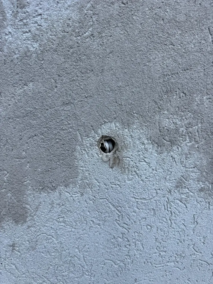 The wall opening left after the old fixture was removed, ready to be patched