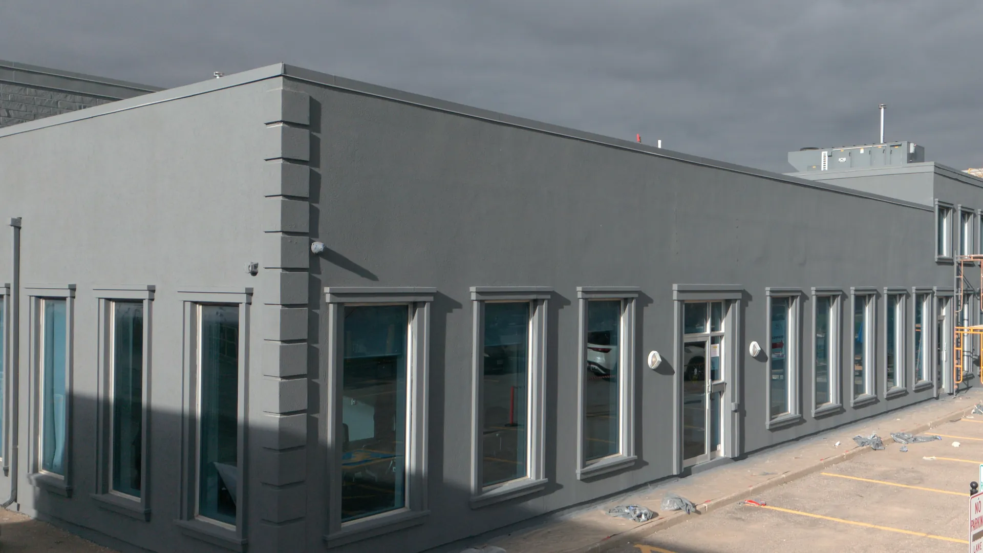 Drone view of a commercial building in Vaughan after FAIME's full envelope repair and repaint, finished in dark grey with light window trim