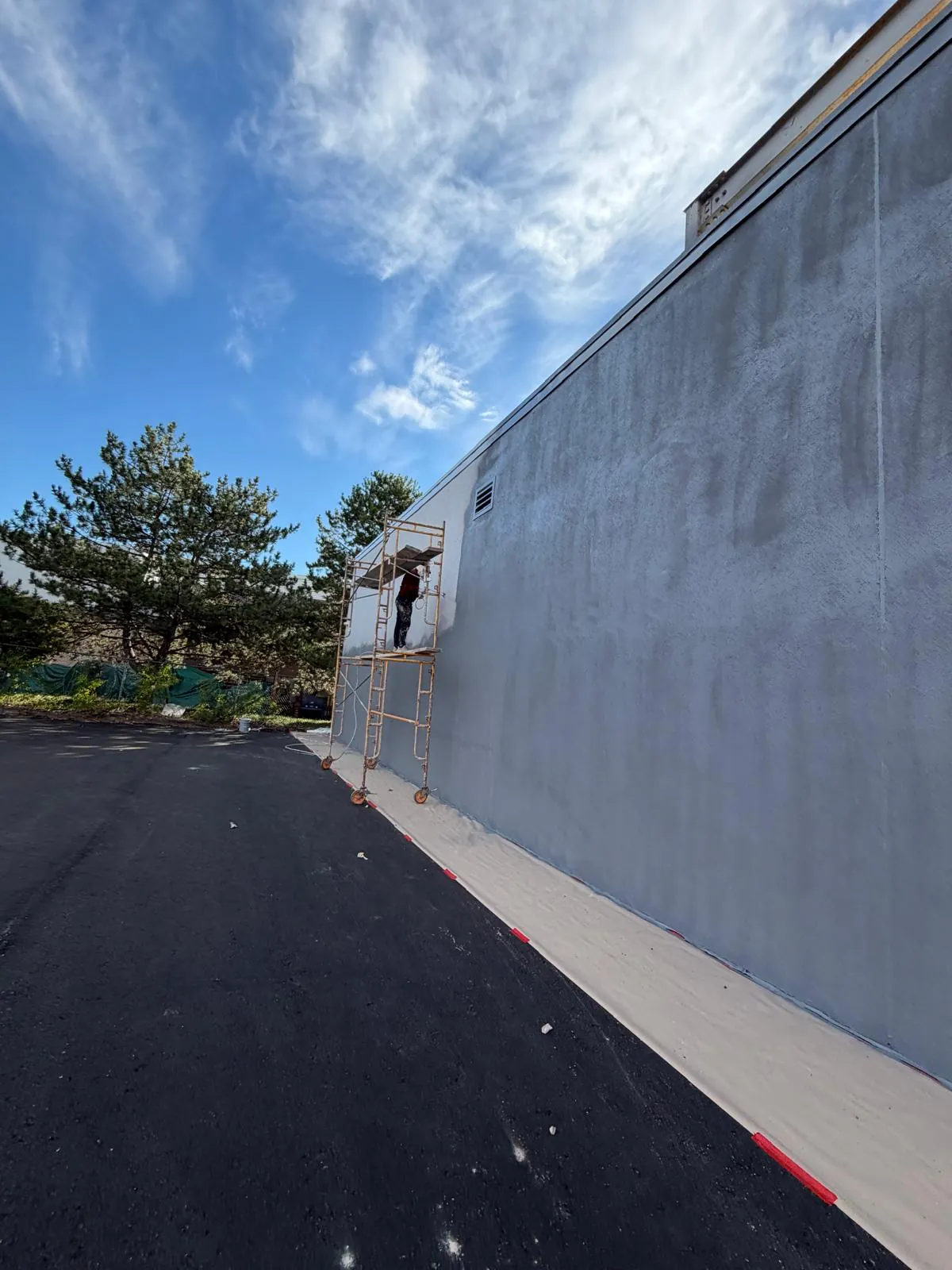 The long wall mid-way through the Venetian finish, patched areas blending into the new coat