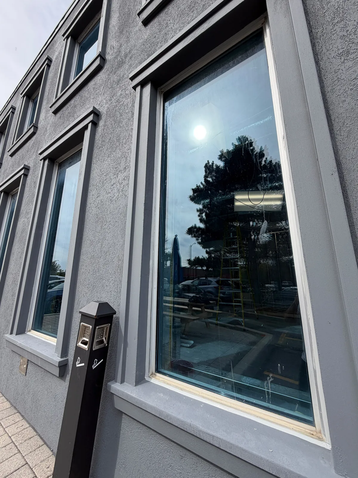 A row of finished window surrounds along the dark grey elevation