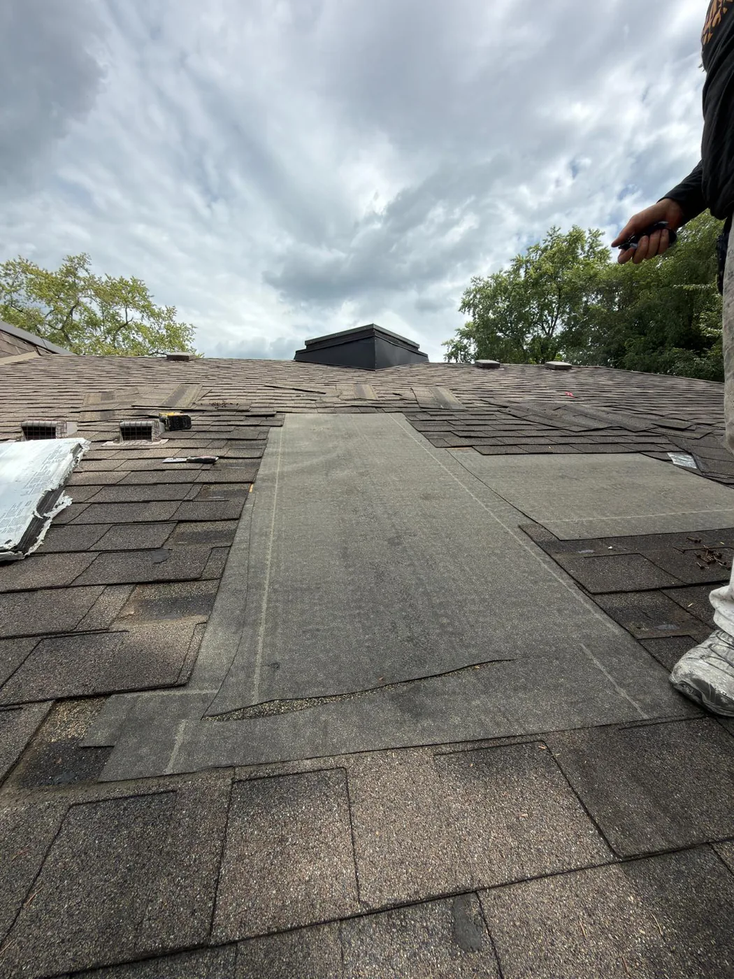Self-adhering membrane underlayment run up the roof slope towards the ridge.