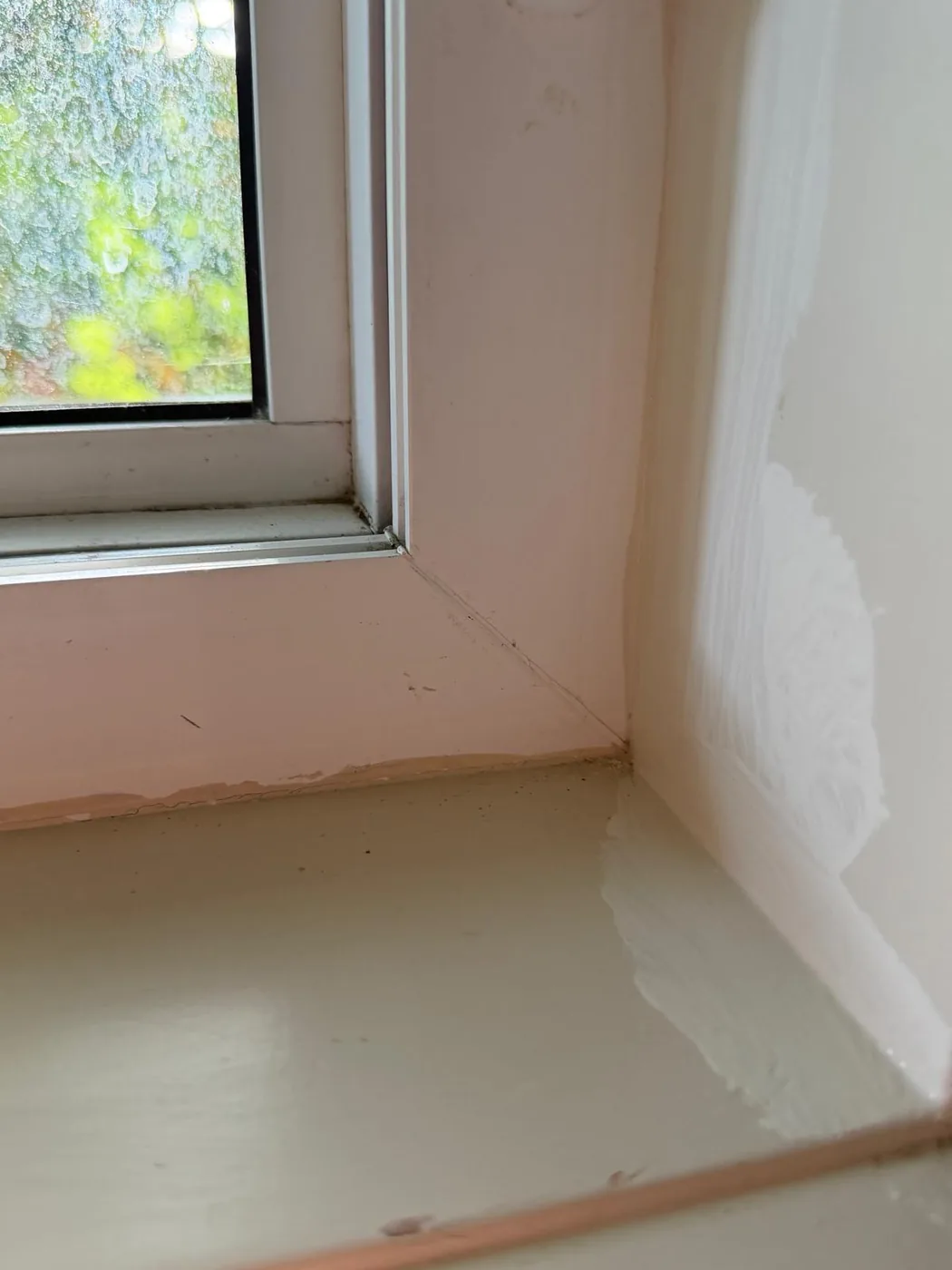 A fresh bead of caulk and paint worked into the corner of an upstairs window sill.
