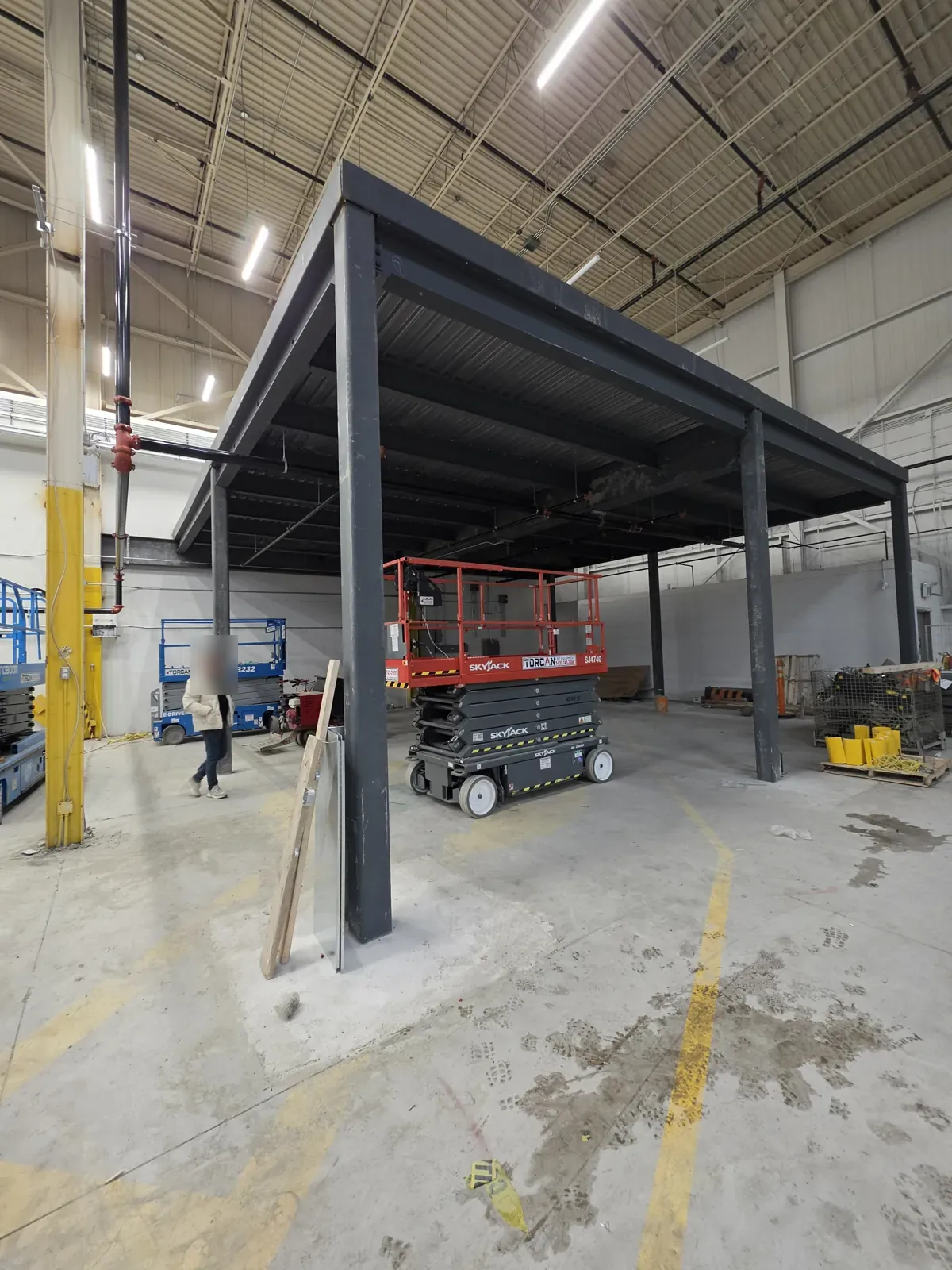 Bare dark-grey steel mezzanine structure before intumescent fireproofing