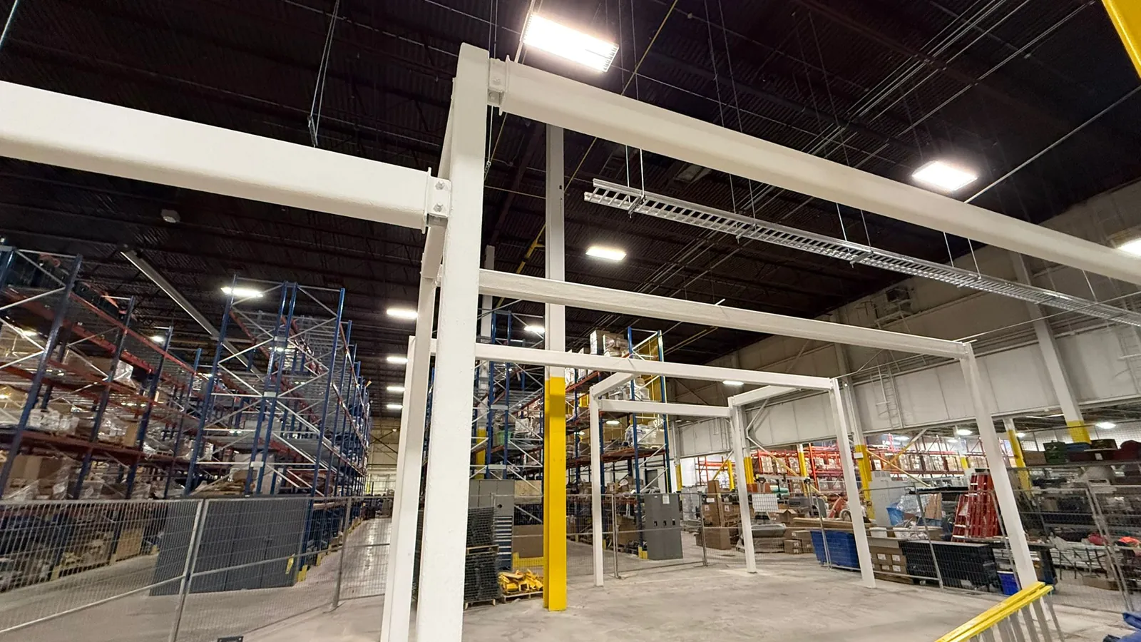 Structural steel frames coated in white intumescent fireproofing inside a Newmarket warehouse